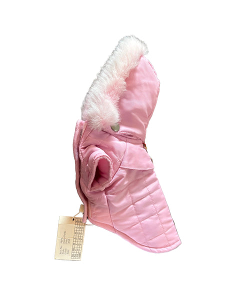A pink quilted winter coat with a fluffy white faux-fur trim and a small silver snap button, laid flat on a gray carpet. A paper size tag is attached near the bottom.